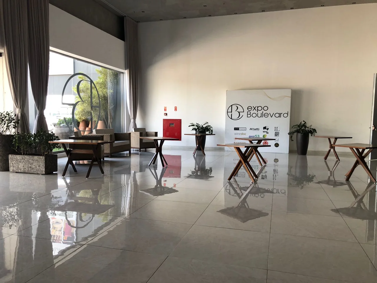 Hall de recepção do Expo Boulevard com luz natural e mobiliário de apoio